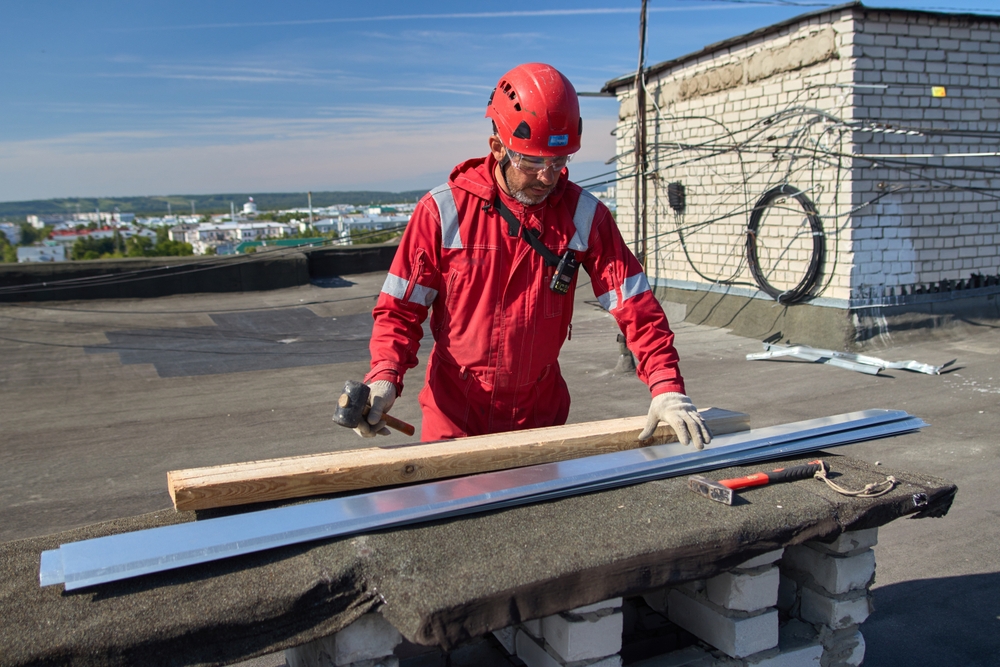 Muž v pracovní helmě pracuje na střeše